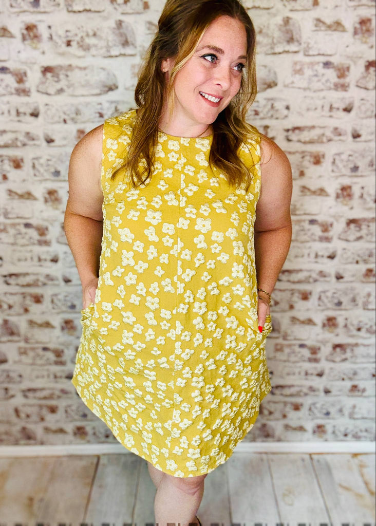 Embossed gold yellow swing dress with white embossed flowers. Sleeveless and pockets