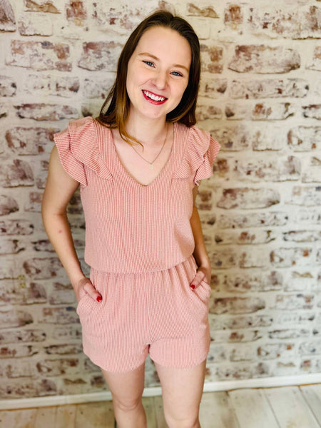 This romper has double ruffled sleeves and a v neck line with 2 pockets on the shorts.