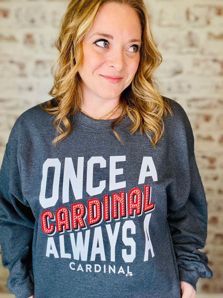The gray sweatshirt has the logo Once a CARDINAL always a cardinal in white and red lettering.