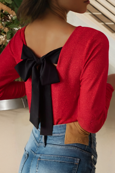 Red top adorns a black bow in the back at the shoulder line the red is slightly metallic in color.