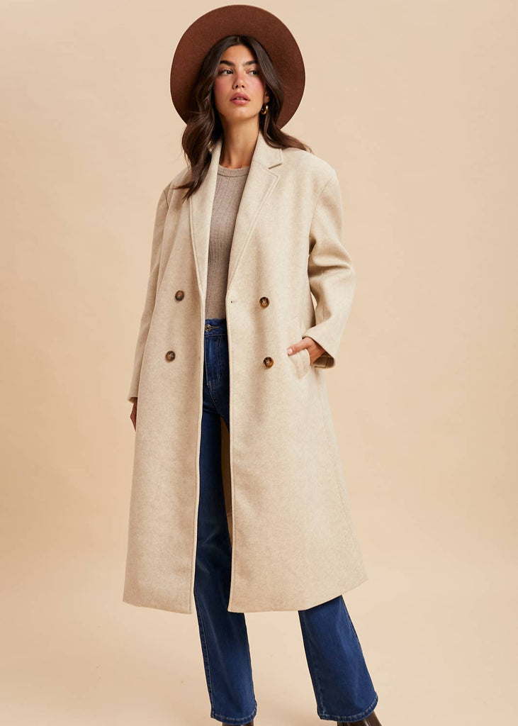 Double-breasted off-white duster coat with side pockets and wood buttons