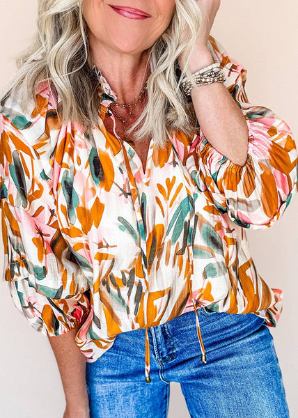 3/4 sleeve gold, sage green and splashes of redish pink flral blouse with a scalloped neck and drawstrings at the neck too.