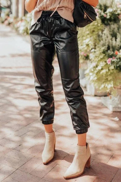 Faux leather joggers are adjustable waist with elastic and a draw string sand and elastic hem at the ankle.