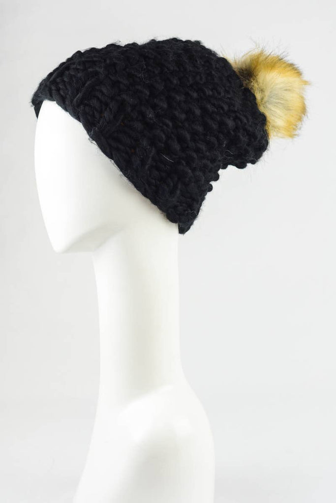 Black oversized textured beanie with a pom adorned atop in faux fur