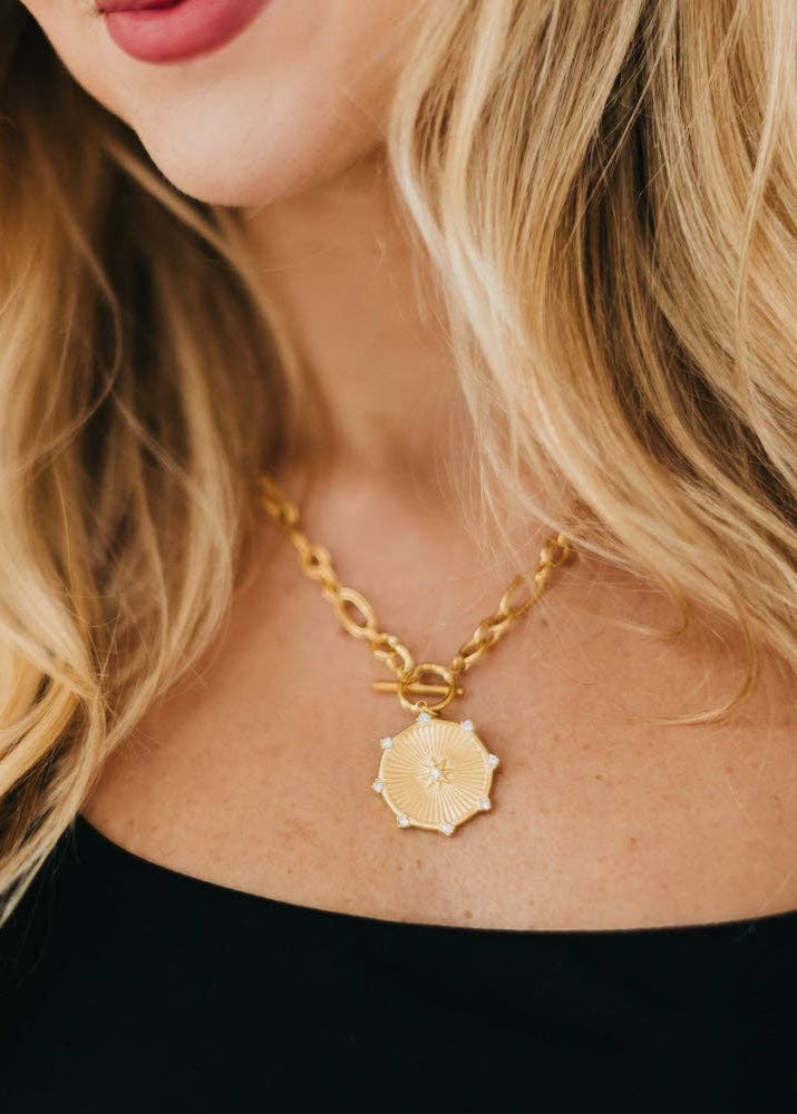 this waterproof Sunburst Diamond Chain Necklace in gold, this necklace features a thick chain, a toggle clasp, and a beautiful sunburst pendant with diamonds on it. 19.5 inches