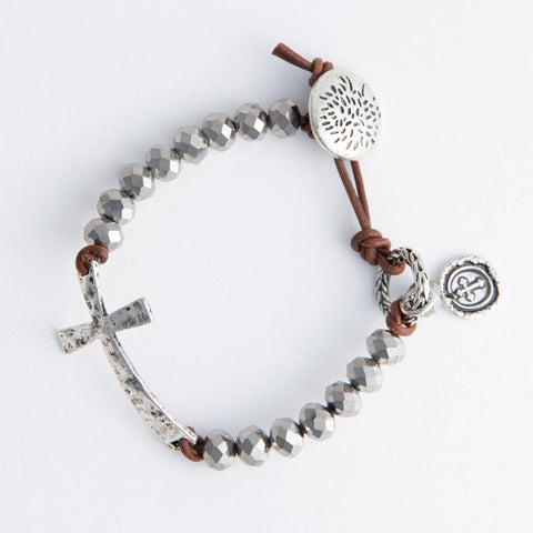 This boho style Ivy cross bracelet is both beaded and clasps with a leather band.  the cross is on its side for comfort and a gentle fit to the wrist