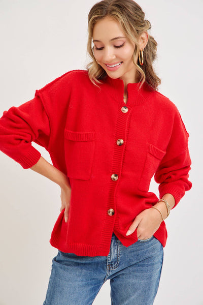 Bold red knit cardigan with a mock collar and patch pockets.  The fit is relaxed, and the trim is ribbed with stated buttons for closure