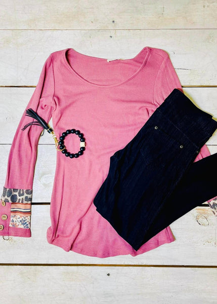 pink waffle knit sweater with print and buttons on the cuff